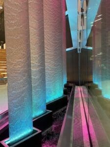 This water feature includes five metal mesh panels with a pink down lighting and aqua up lighting.